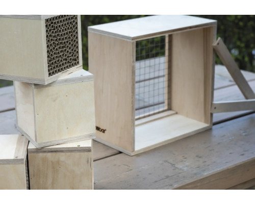 Insektenhotel aus Holz mit Niströhren und Gitter