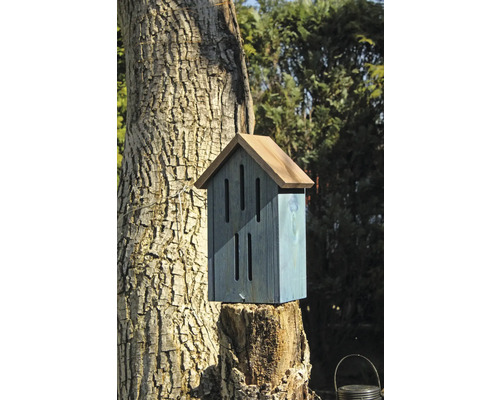 Insektenhotel aus Holz auf Baumstumpf im Garten