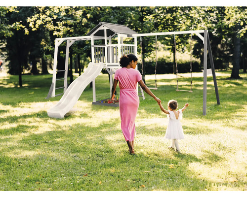 Spielplatzgerät mit Rutsche, Schaukel und Spielturm im Garten