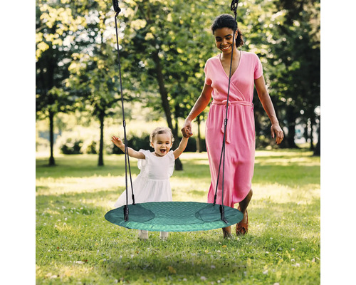 Mutter und Kind mit runder Gartenschaukel im Freien