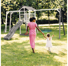 Spielplatz mit Rutsche, Schaukel und Spielturm im Garten.