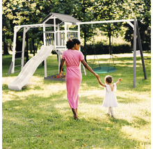 Spielplatz mit Turm, Rutsche und Schaukel für Kinder im Garten.