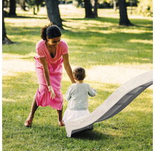 Mutter und Kind am Rutschen auf einer Kinderrutsche im Garten.