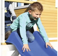 Kind rutscht auf einer blauen Rutsche eines Spielhauses.