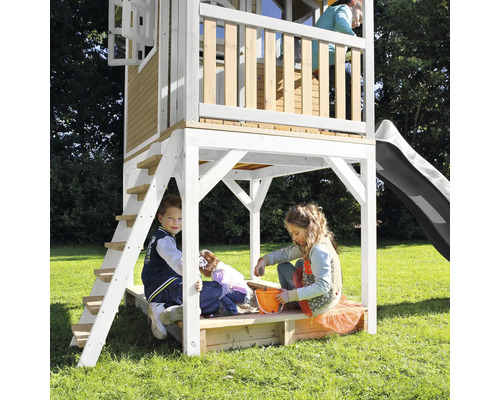 Spielhaus mit Rutsche, Leiter und Sandkasten für Kinder im Garten.