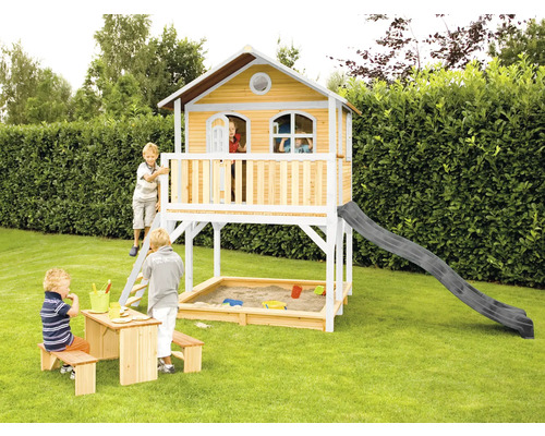 Holzspielhaus mit Rutsche, Sandkasten und Kindersitzgruppe im Garten