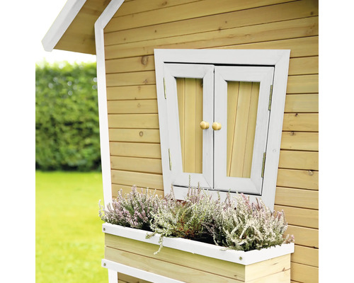 Detailansicht eines Holzspielhauses mit Fensterladen und Blumenkasten