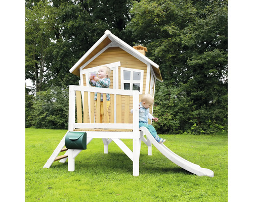 Spielhaus aus Holz mit Rutsche und Briefkasten im Garten mit zwei Kindern