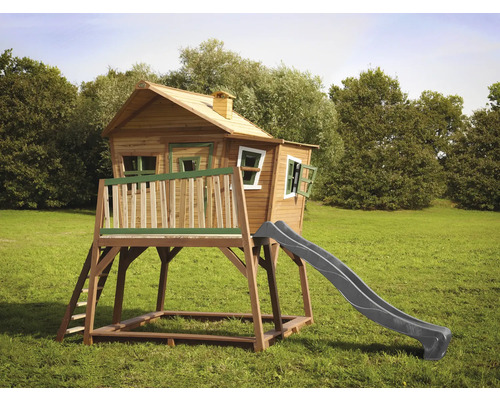 Holzspielhaus mit Rutsche und Leiter auf einer Wiese