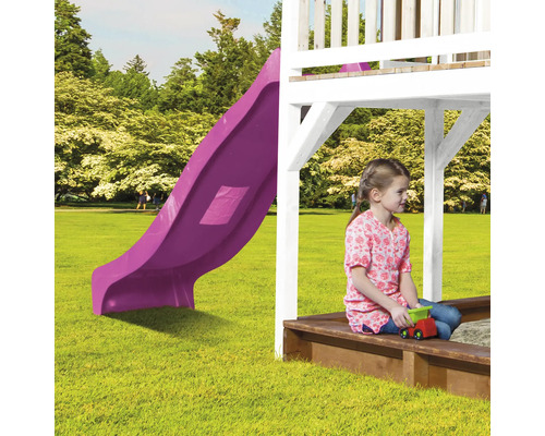 Spielplatz mit lila Rutsche und spielendem Kind im Sandkasten