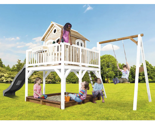 Spielplatz mit Spielhaus, Rutsche, Schaukel und Sandkasten im Garten mit spielenden Kindern.