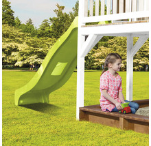 Kind sitzt in Sandkiste unter Spielturm mit Rutsche im Garten