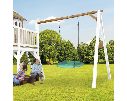 Spielturm mit Schaukel und zwei spielenden Kindern auf einer Rasenfläche.