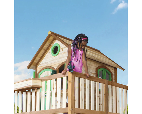 Kind schaut aus einem hölzernen Spielhaus mit Fernrohr