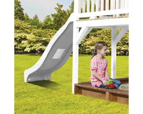 Spielplatz mit Rutsche, Sandkasten und spielendem Kind