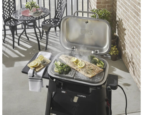 Weber Lumin Elektrogrill mit Fisch und Gemüse auf dem Grillrost.