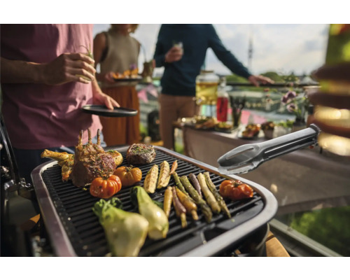 Grillszene mit Fleisch, Gemüse und Grillzange bei einer Gartenparty.