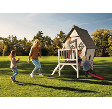 Spielhaus mit Rutsche im Garten mit spielenden Kindern und Erwachsenen