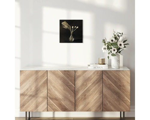 Dekoratives Bild mit getrockneten Blumen in einer Vase an einer Wand über einem Sideboard