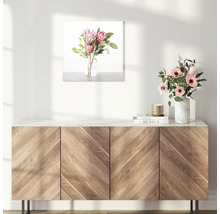 Dekoratives Bild mit Blumenarrangement über einem Holzschrank.