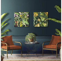 Wohnzimmer mit zwei Sesseln, kleinem Tisch und zwei Deko-Bildern mit Pflanzenmotiven an der Wand