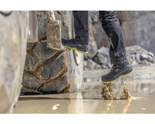 Uvex Logo Sicherheitsstiefel beim Betreten einer Wasserpfütze auf einer Baustelle