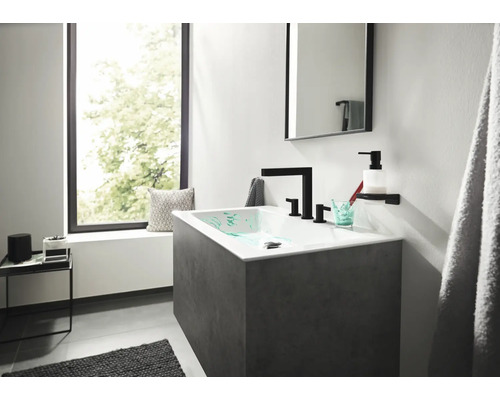 Modernes Badezimmer mit Waschtisch, Spiegel und Accessoires.