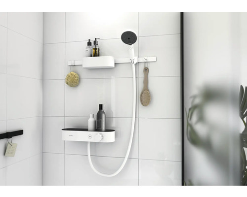 Duschregal mit Brause und Badutensilien an einer gefliesten Wand.