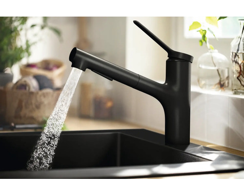 Schwarze Küchenarmatur mit ausziehbarer Brause und fließendem Wasser in einem Spülbecken