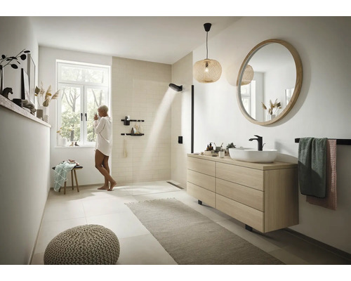 Helles Badezimmer mit Dusche, Waschtisch mit Spiegel, Handtuchhalter und Dekoration