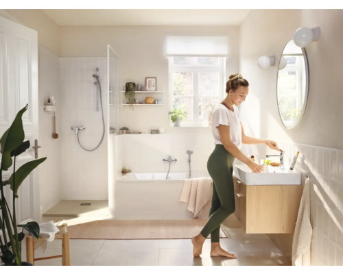 Helles Badezimmer mit Badewanne, Dusche, Waschtisch und Spiegel