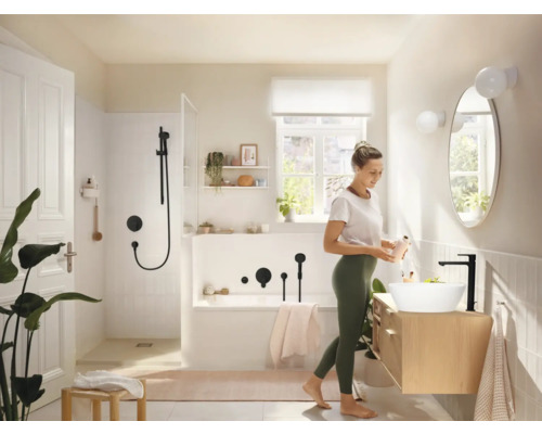 Helles Badezimmer mit Badewanne, Dusche, Waschbecken und Frau