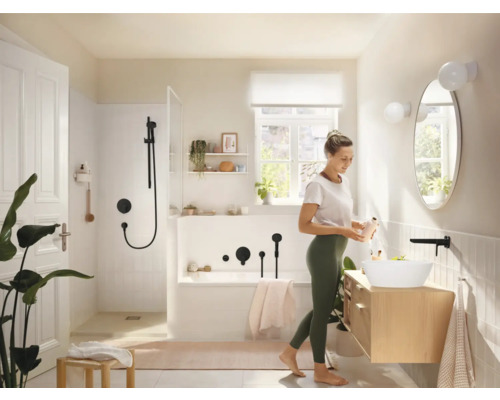 Helles Badezimmer mit Dusche, Badewanne, Waschtisch und einer Frau