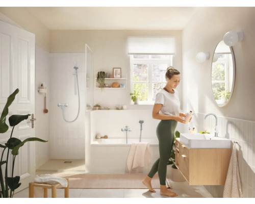 Helles Badezimmer mit Badewanne, Dusche, Waschbecken und Spiegel in freundlichem Design.