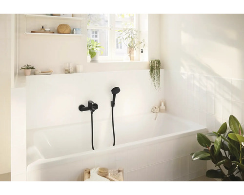 Helles Badezimmer mit Badewanne und schwarzer Armatur