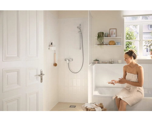 Helles Badezimmer mit Dusche, Badewanne und einer Frau mit Handtuch