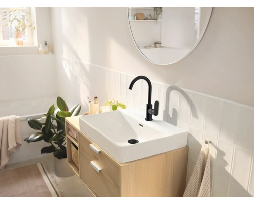 Helles Badezimmer mit Waschbecken, schwarzer Armatur und Spiegel