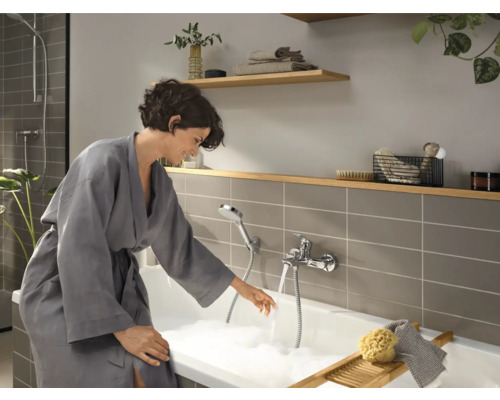 Badezimmer mit Badewanne, Armatur und Frau im Bademantel