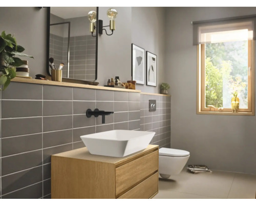 Badezimmer mit Waschtisch, Aufsatzwaschbecken, Spiegel und Toilette in hellem Design