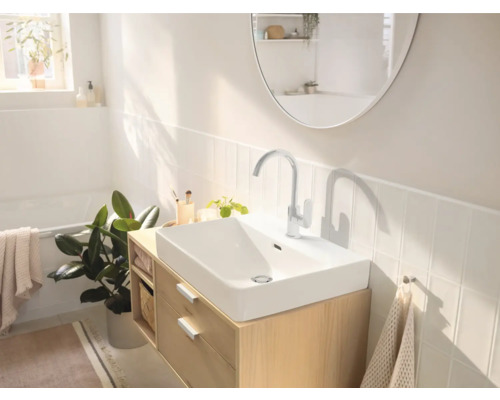 Helles Badezimmer mit Waschbecken, Armatur, Spiegel und Holzunterschrank