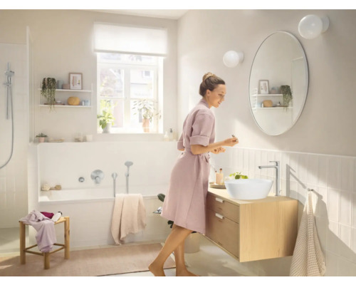 Helles Badezimmer mit Waschtisch, Aufsatzwaschbecken, Armatur, Spiegel und Badewanne.