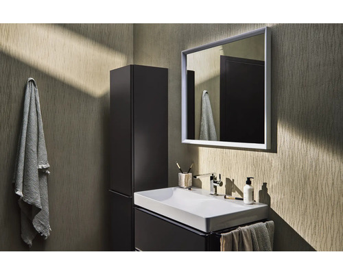 Badezimmer mit Waschbecken, Spiegel, Hochschrank und Handtüchern