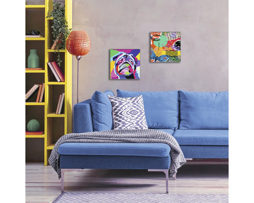 Wohnzimmer mit blauem Sofa, gelbem Regal und Wandbildern