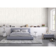 Helles Schlafzimmer mit Bett, Nachttischen, Bücherregal und Tapete in Holzoptik.