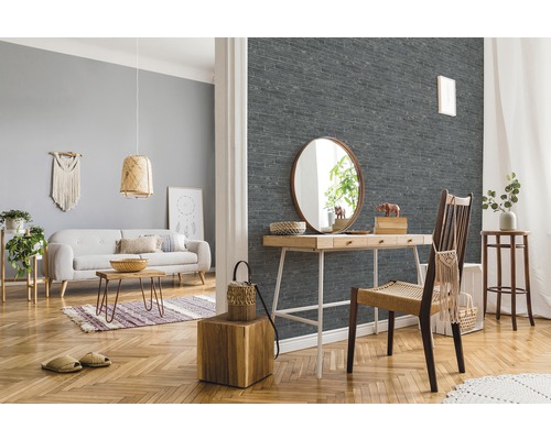 Wohnzimmer mit Sofa, Tisch, Stuhl und einer Wand mit Steinoptik Tapete