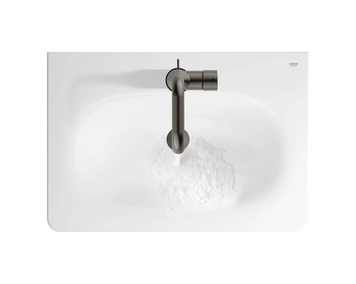 Draufsicht auf ein Waschbecken mit Armatur und fließendem Wasser