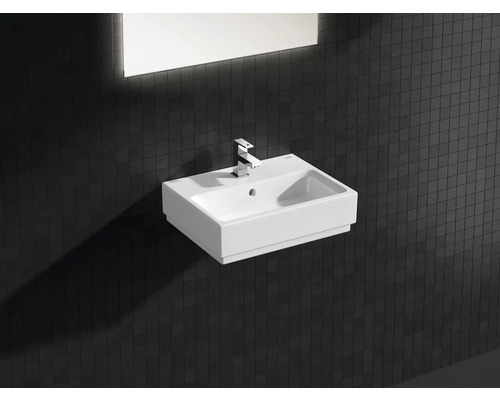 Keramikwaschbecken mit Armatur und rechteckigem Spiegel im Badezimmer.