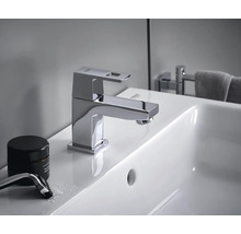 Auf einem Waschbecken ist eine glänzende Grohe Armatur mit eckigem Auslauf zu sehen.