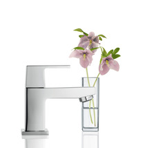 Moderner Wasserhahn aus Metall neben Blumen in Vase für das Badezimmer