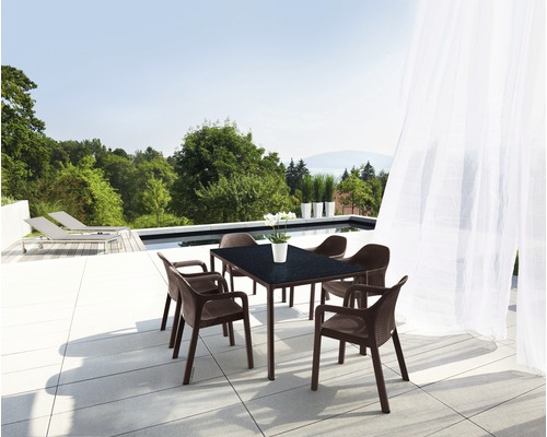 Gartensitzgruppe mit Tisch und Stühlen auf einer Terrasse mit Poolblick